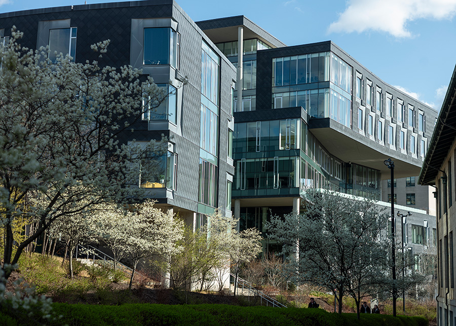The exterior of a large modern building that is mostly black with many windows.