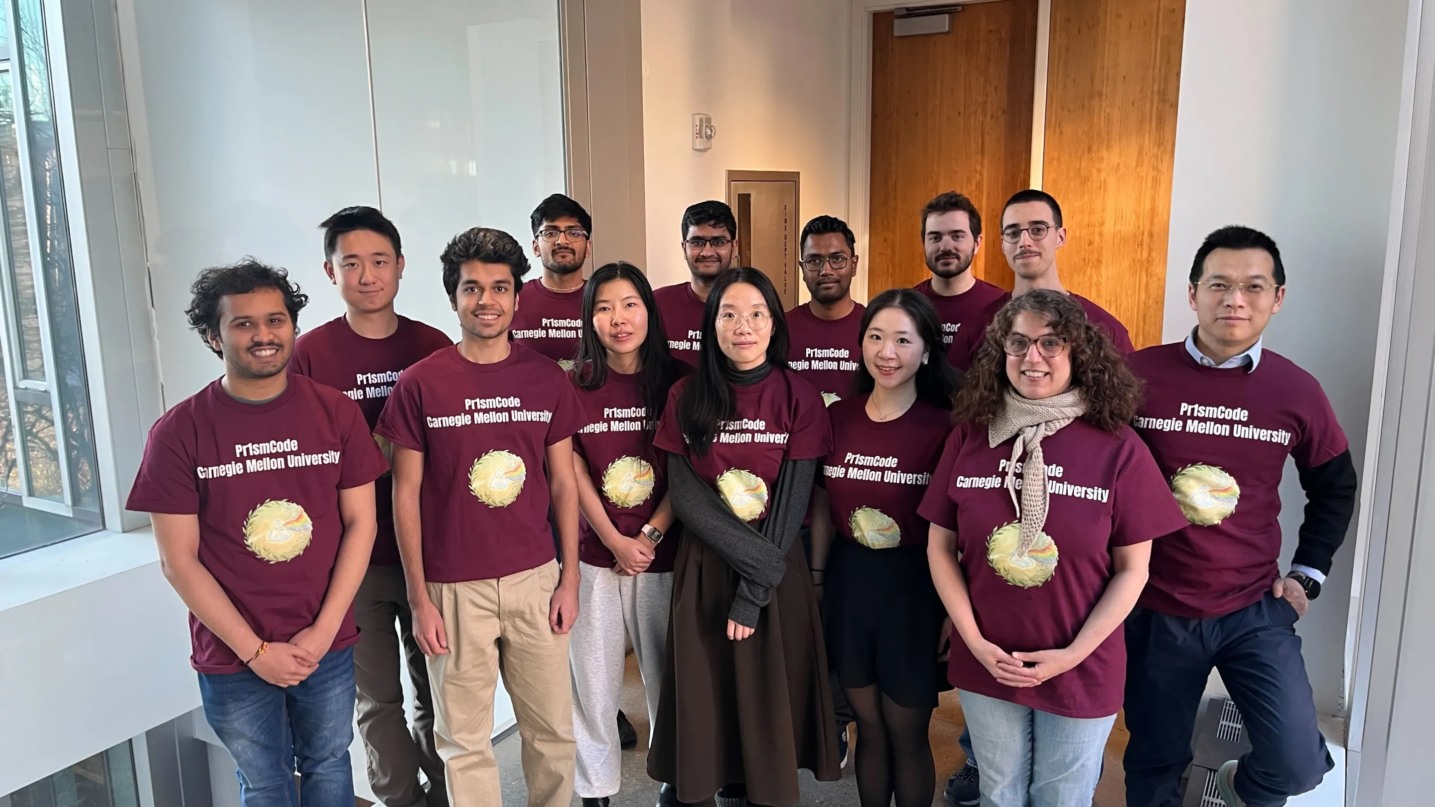 Members of team Pr1smcode pose in a hallway wearing maroon team t-shirts